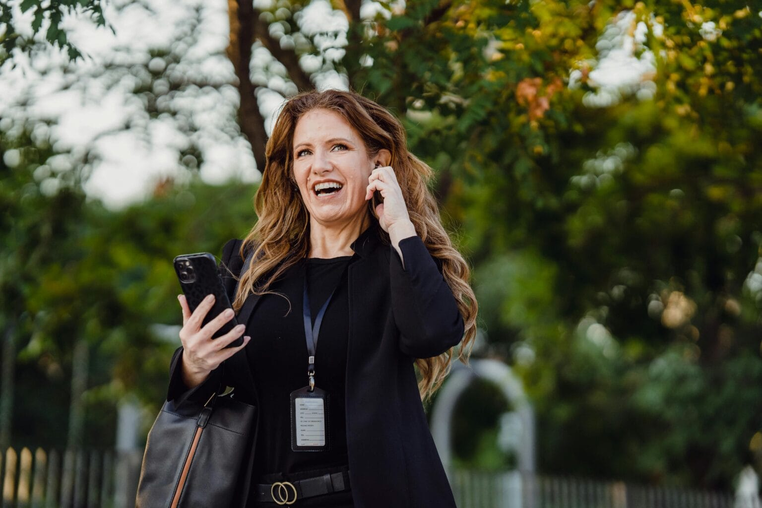 Smiling woman in a park making a phone call with confidence.